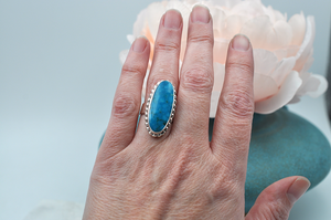 View of oblong Kingman turquoise ring on model's hand for scale. US Size 7