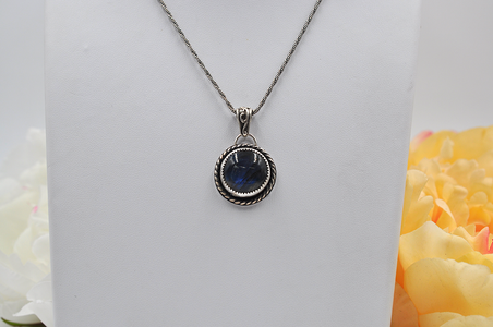 Silver necklace with a blue labradorite pendant on a white background