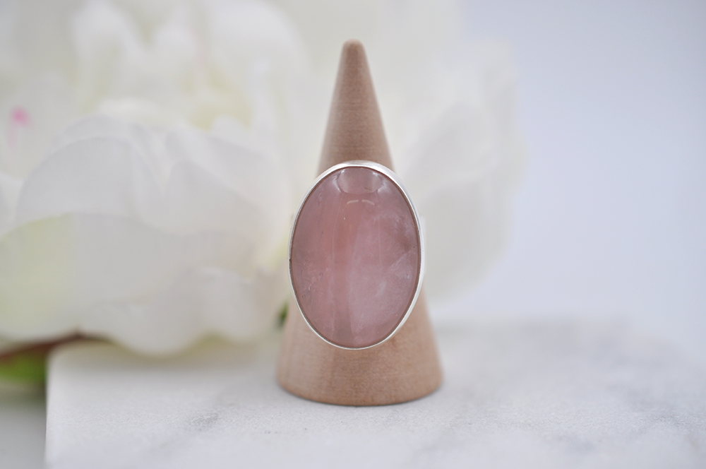 Siver ring with a pink stone on a white background