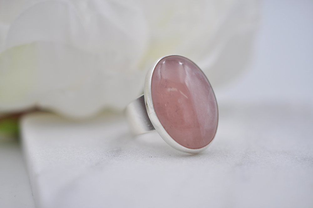 Silver ring with a pink stone on a white background
