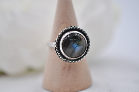 Silver ring with a blue gemstone on a neutral background