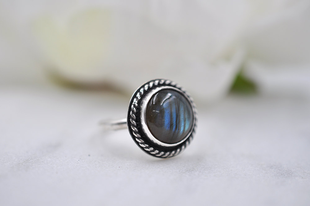 Silver ring with a blue stone on a white background