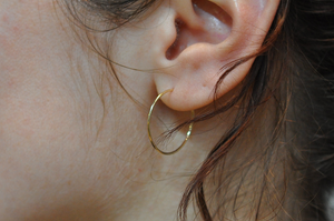 Light weight classic gold hoops are lightweight and perfect for everyday wear. These small wire hoop earrings hang an inch below the ear as pictured in this side view.