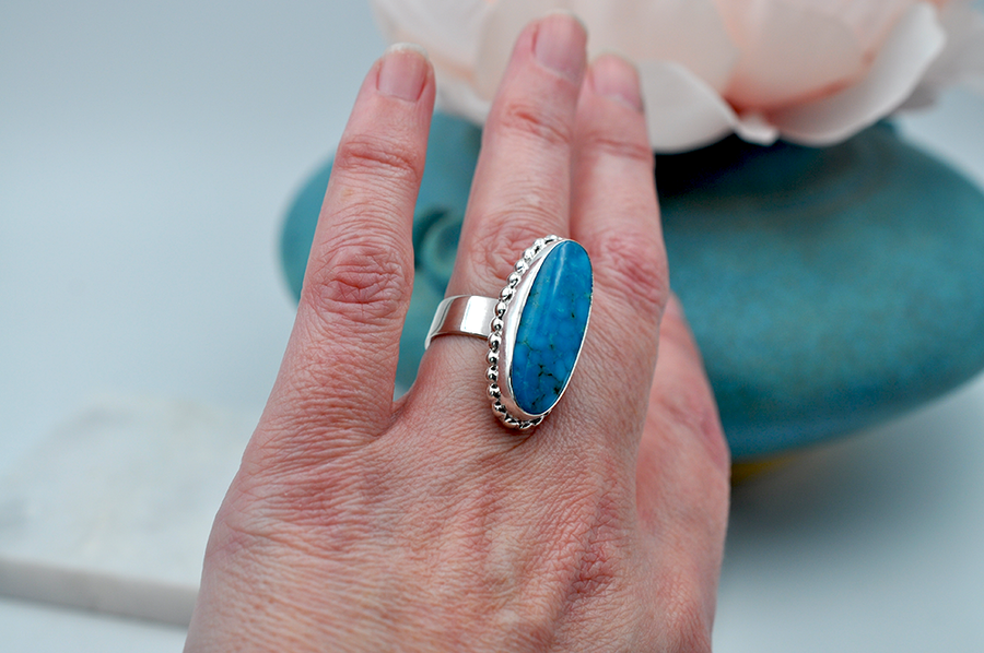 An oblong oval bright blue Kingman turquoise ring is set sterling silver is sure to stand out. US Size 7
